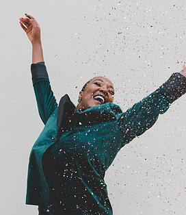 A woman celebrating with confetti falling down